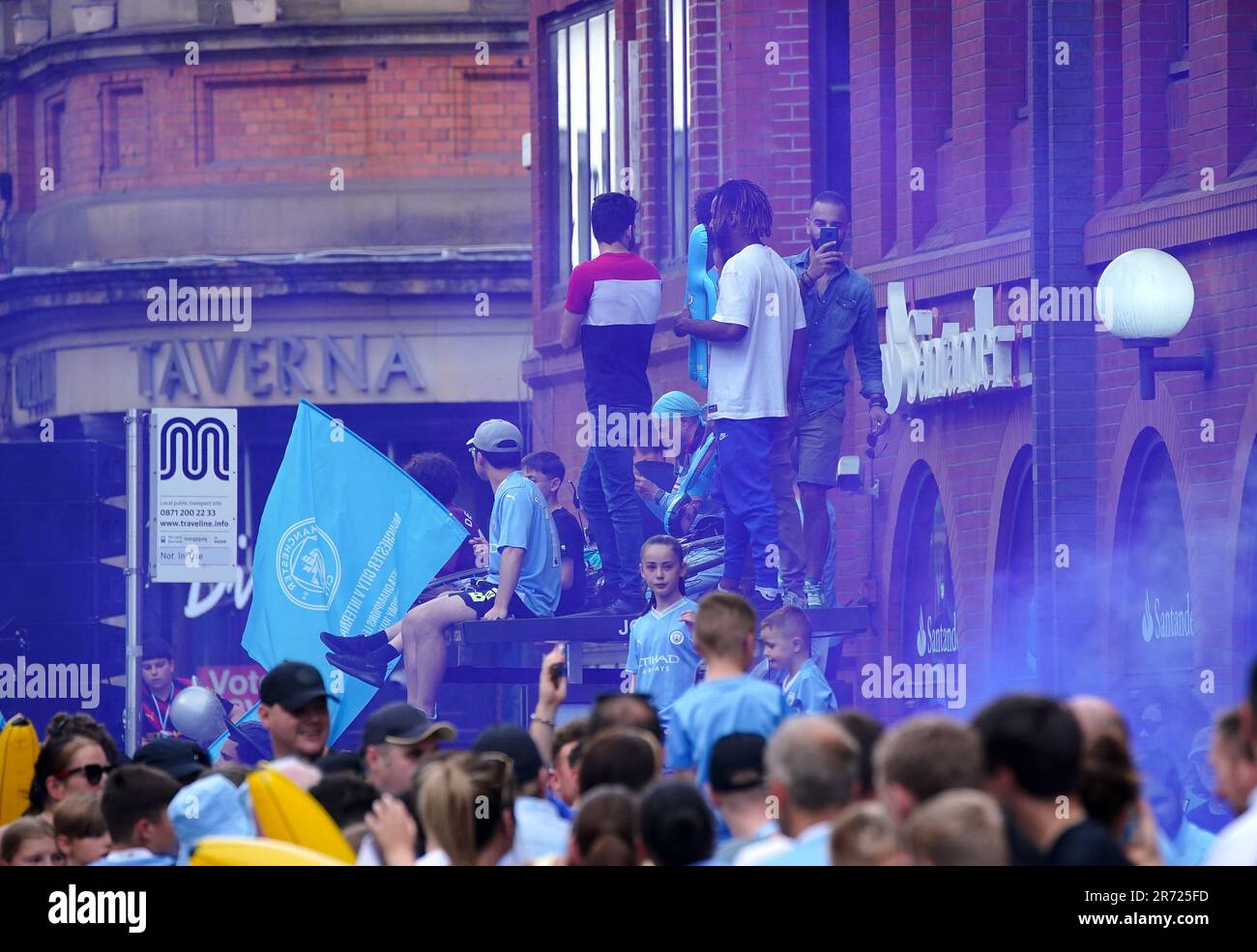 Die Fans von Manchester City stehen an einer Bushaltestelle vor der Treble Parade in Manchester. Manchester City schloss die Treble (Champions League, Premier League und FA Cup) nach einem Sieg von 1-0 über Inter Mailand in Istanbul und sicherte ihnen den Ruhm der Champions League. Foto: Montag, 12. Juni 2023. Stockfoto