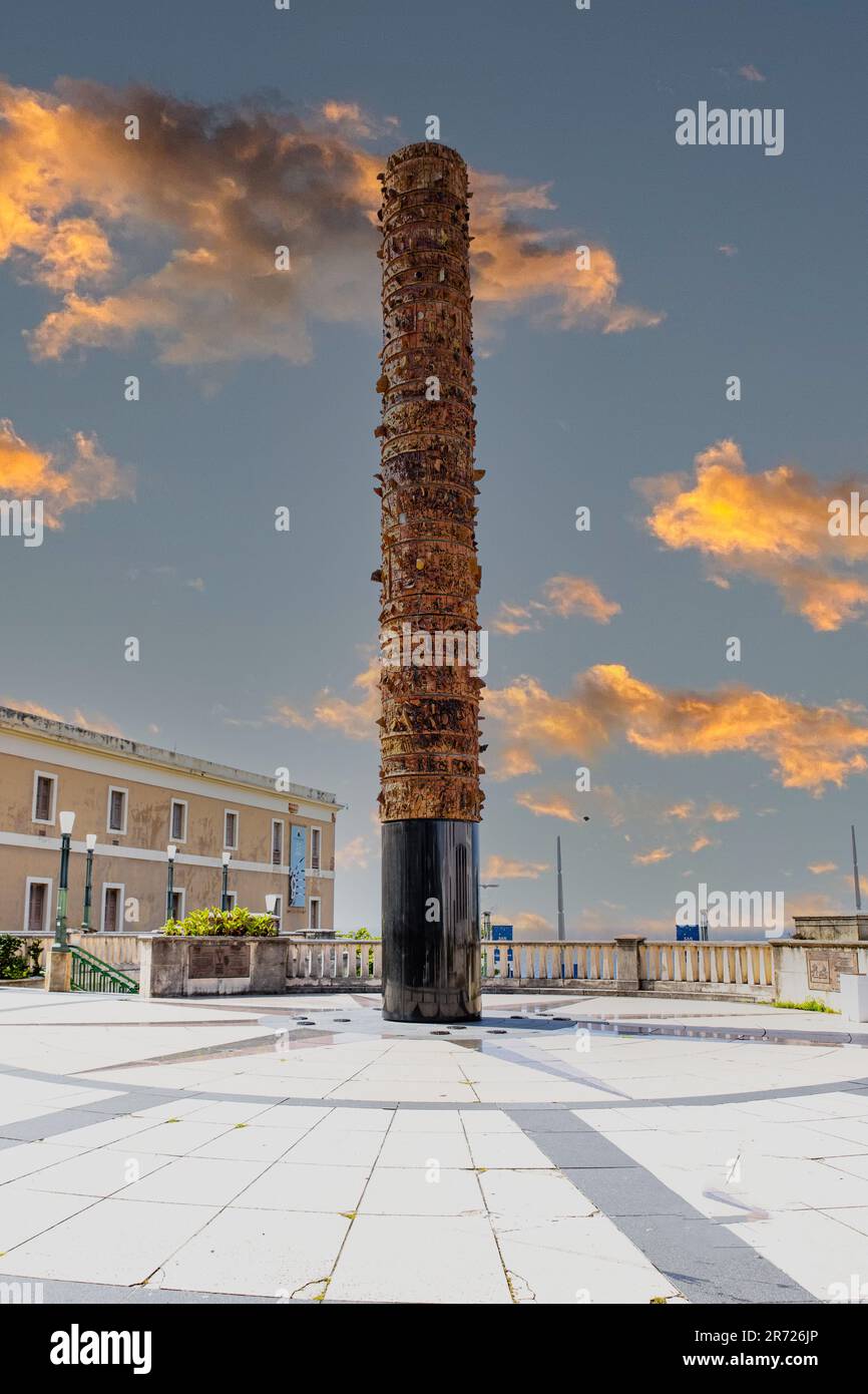 Eine hohe Steinsäule steht in der Mitte eines ruhigen Innenhofs, geschmückt mit Steinen auf der Oberseite Stockfoto