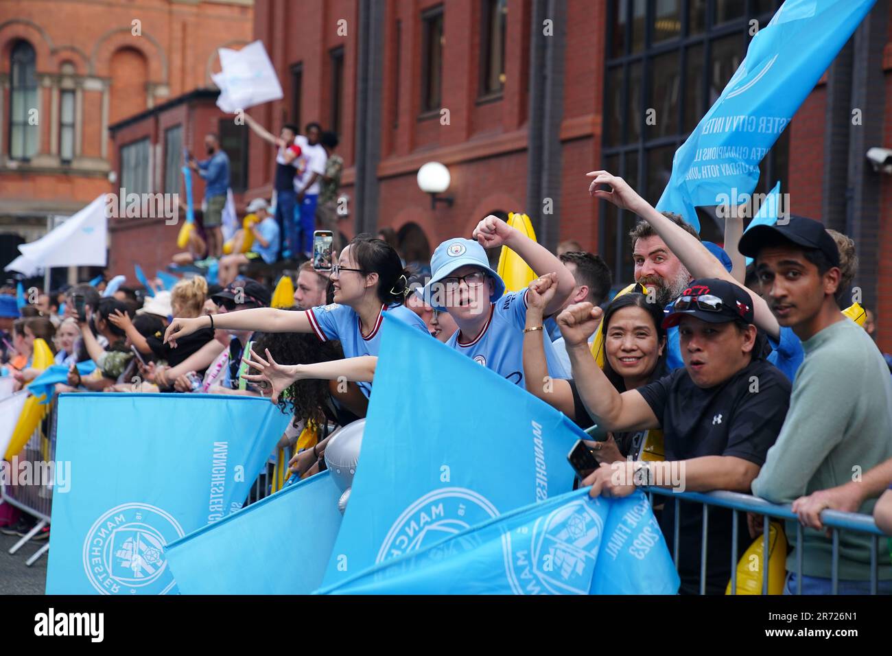 Fans, die vor der Treble Parade in Manchester mit der Flagge wedeln. Manchester City schloss die Treble (Champions League, Premier League und FA Cup) nach einem Sieg von 1-0 über Inter Mailand in Istanbul und sicherte ihnen den Ruhm der Champions League. Foto: Montag, 12. Juni 2023. Stockfoto