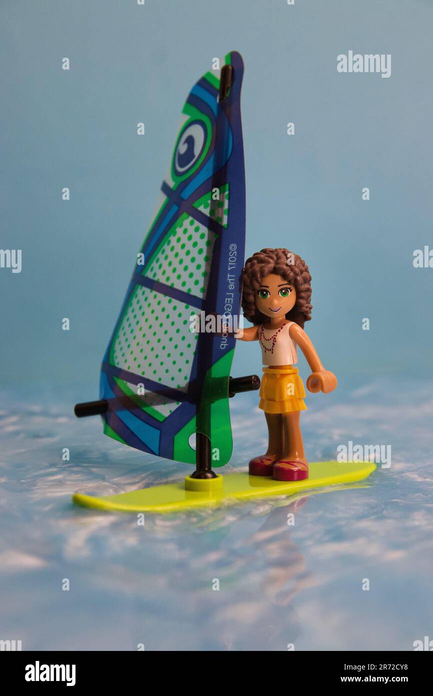 Ein junges Cartoon-Spielzeug steht auf einem Surfbrett im Wasser Stockfoto