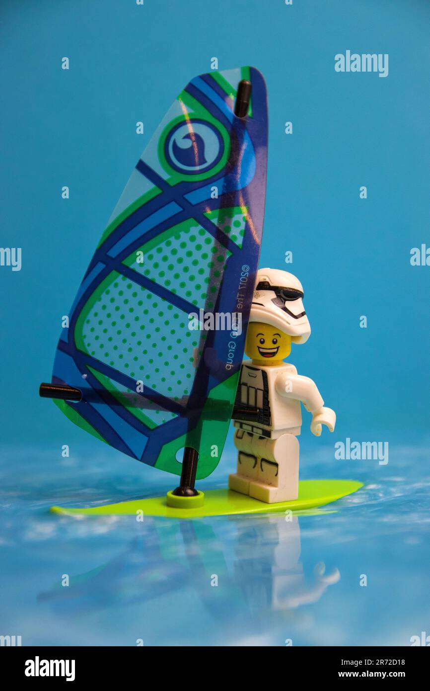 Ein junges Cartoon-Spielzeug steht auf einem Surfbrett im Wasser Stockfoto