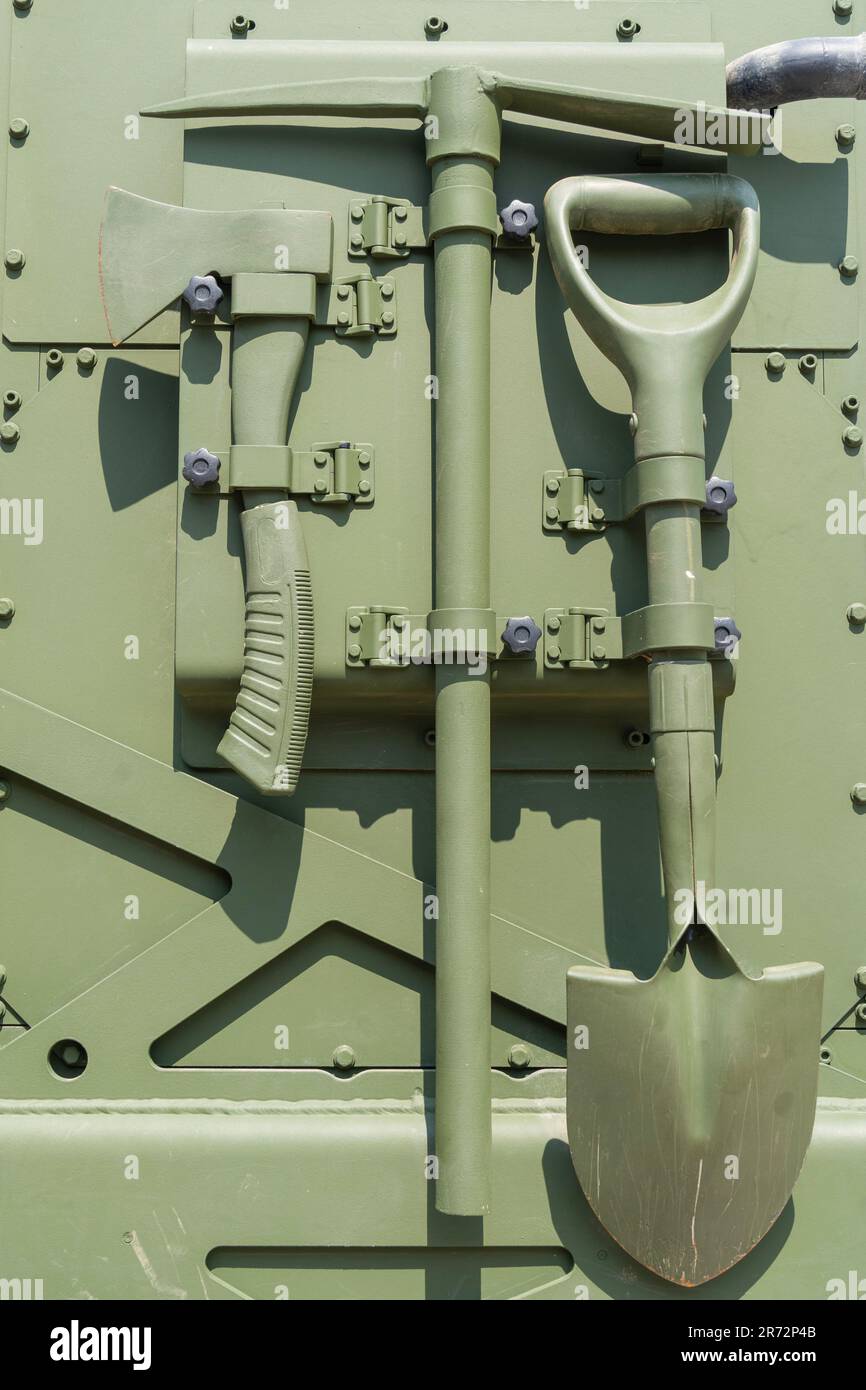 Werkzeuge an der Seite eines grünen gepanzerten Fahrzeugs befestigt Stockfoto