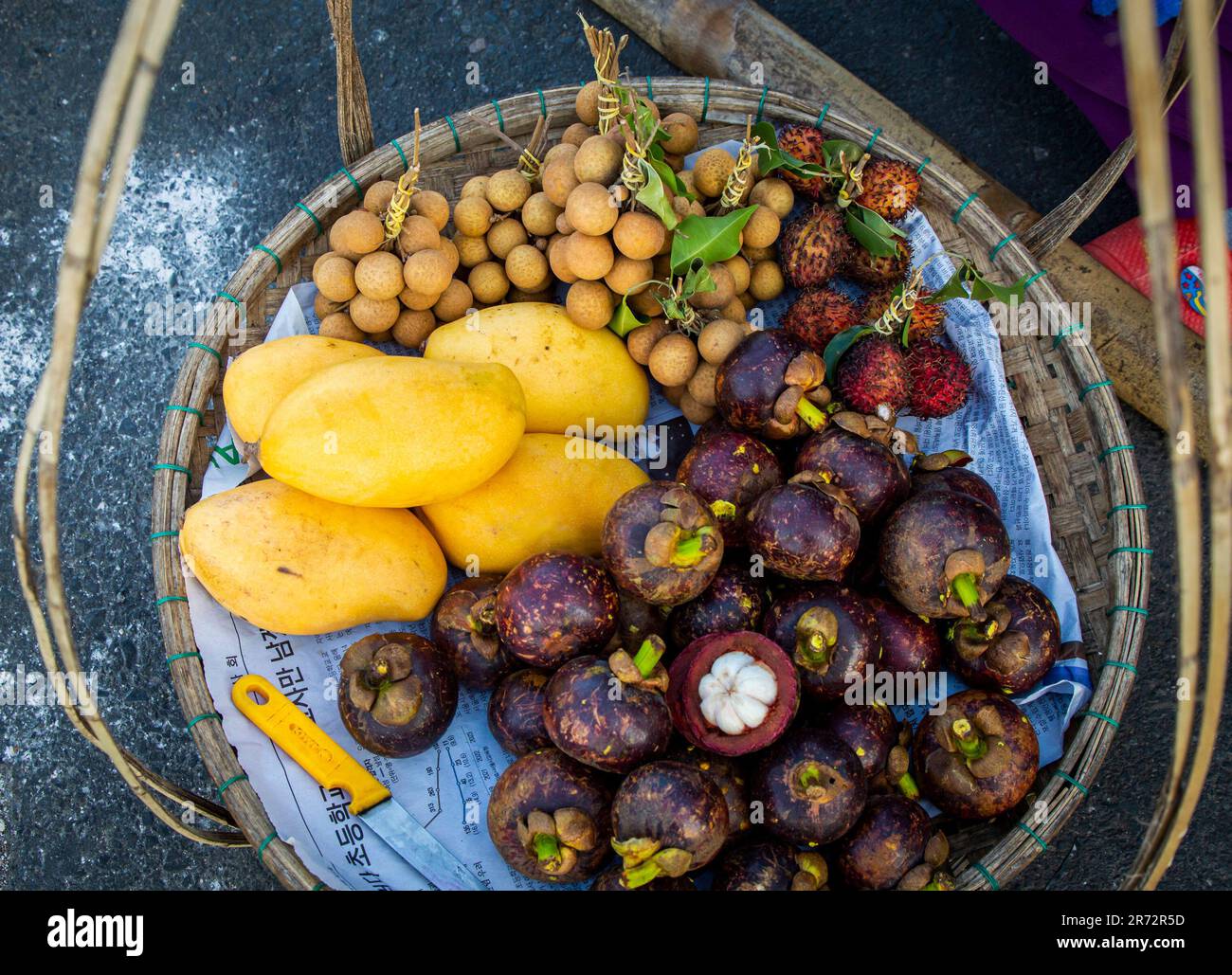 Blick von oben auf farbenfrohe, frische tropische Früchte im Korb an der Vietnam Local Street, einschließlich Mango, Litschi, Longan und Mangoteen Stockfoto