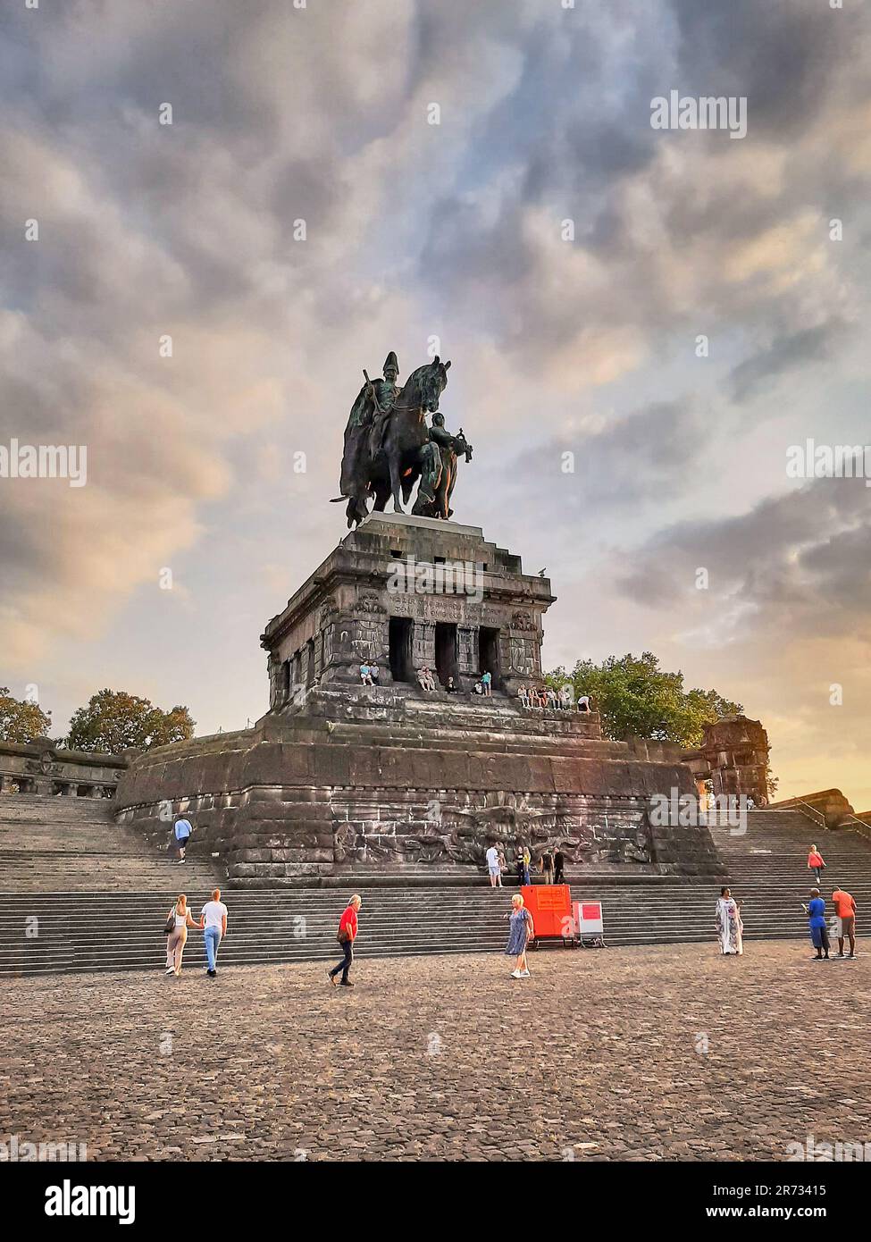 Dramatische Wolken bei Sonnenuntergang und goldene Lichter heben das berühmte Kaiser-Wilhelm-Denkmal am Deutschen Eck hervor, das Symbol der deutschen Vereinigung - Koblenz Stockfoto