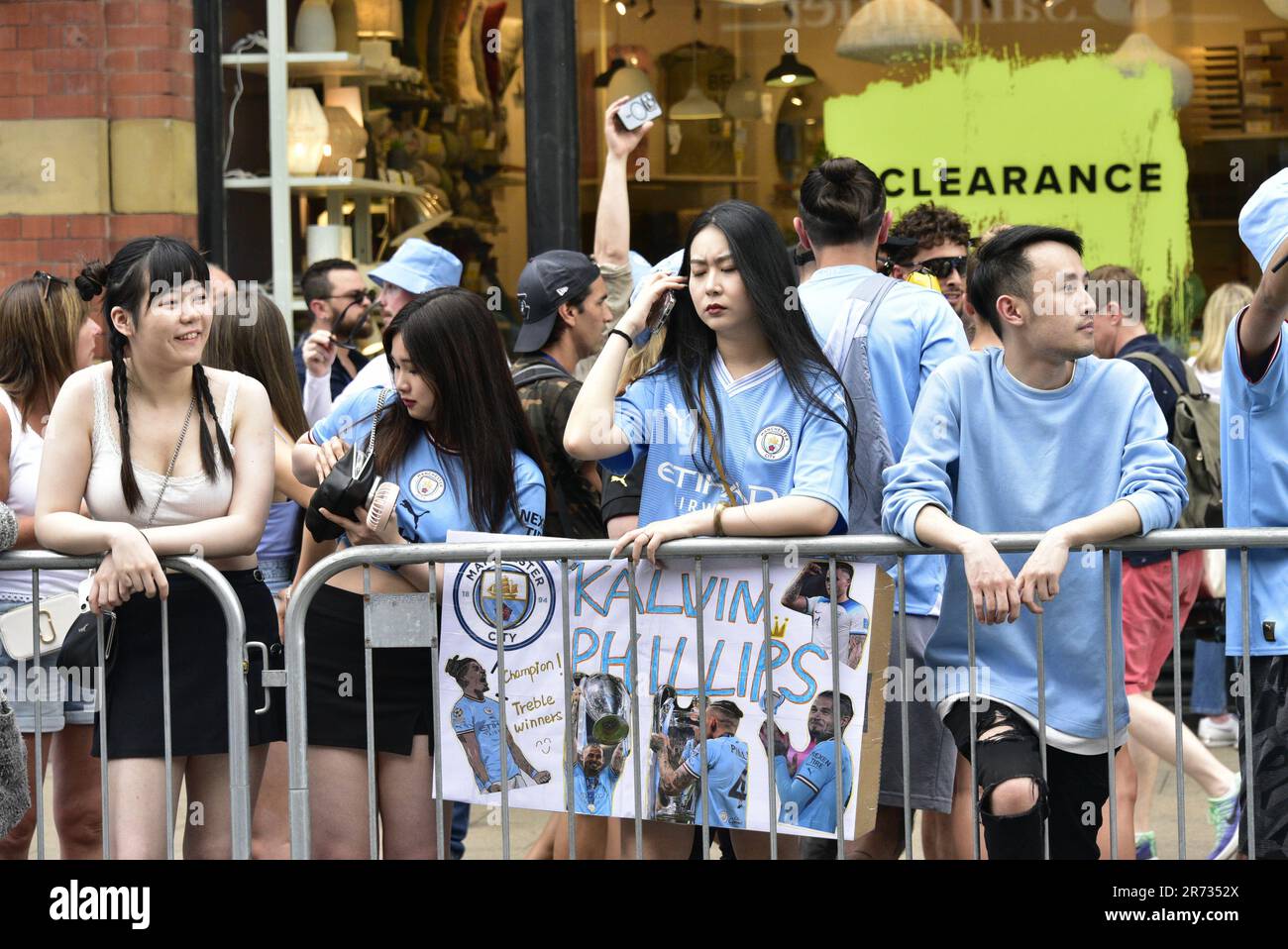 Manchester, Großbritannien. 12. Juni 2023. Ein Fan hält ein selbstgemachtes Plakat über den man City Spieler Kalvin Phillips, während die Fans warten, während der Manchester City Football Club sich auf eine Siegesparade mit offenem Oberdeck im Zentrum von Manchester, Großbritannien, vorbereitet, um den Sieg der Treble zu feiern: Die Premier League, der FA Cup und die Champions League. Am Samstag besiegte man City Inter Mailand in Istanbul und sicherte sich den Champions League-Sieg. Die Parade der offenen Busse fuhr durch das Stadtzentrum von Manchester und beobachtete von großen, begeisterten Massen, trotz Gewitter und starkem Regen. Kredit: Terry Waller/Alamy Live News Stockfoto