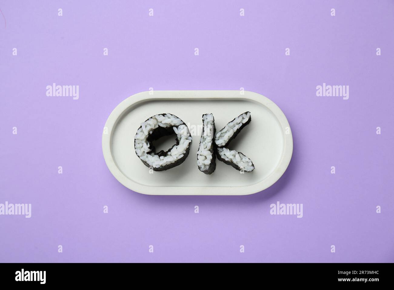 Wort OK aus Sushi-Brötchen auf violettem Hintergrund, Draufsicht Stockfoto