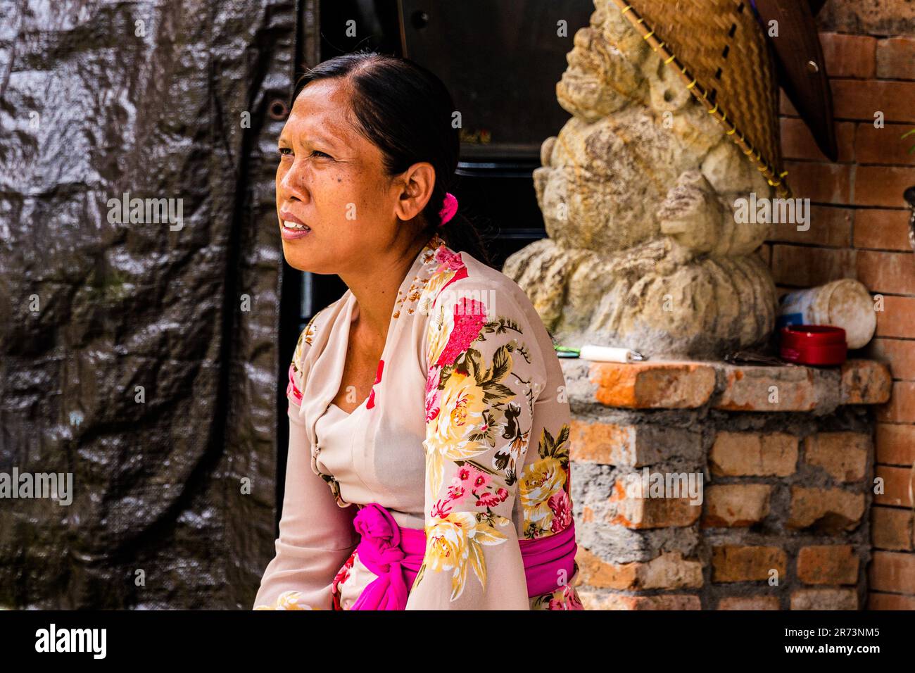 Bali-, Indonesien-- 27. Februar 2023. Das Porträt einer Indosesianerin mit einem komischen Ausdruck in Bali, Indonesien. Stockfoto
