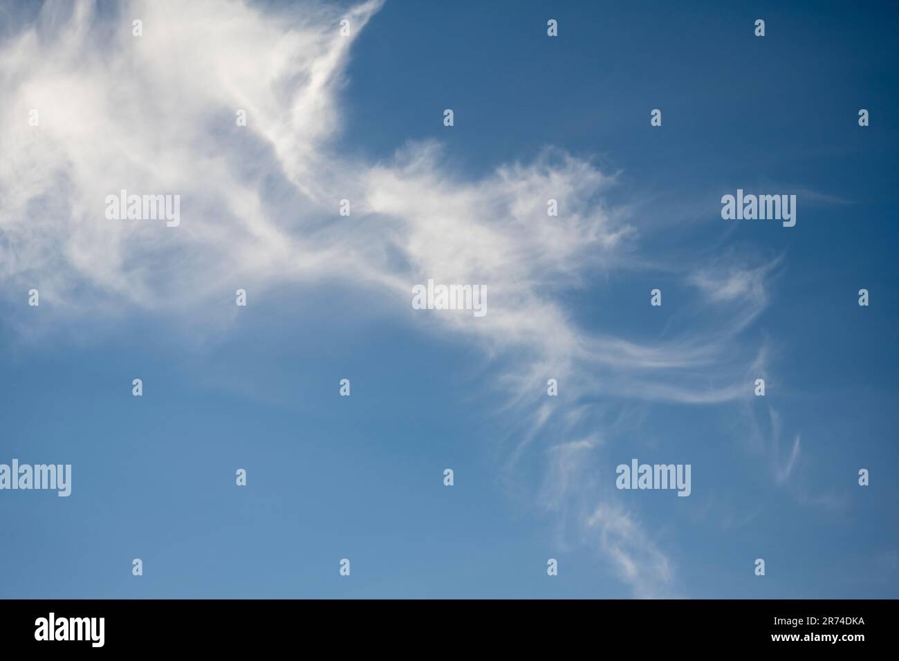 Helle Cirrus-Wolken am blauen Himmel Stockfoto