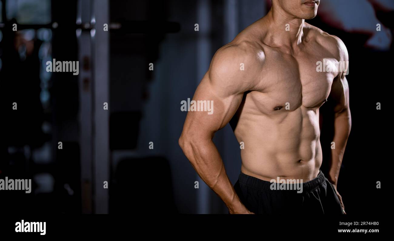 Starker Mann mit großen Muskeln im Fitnessstudio. Fitnesskonzept Stockfoto