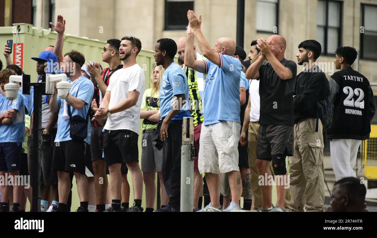 Manchester, Großbritannien. 12. Juni 2023. Die man City-Fans standen auf einer Baustelle, um die Siegesparade mit offenem Oberdeck im Zentrum von Manchester, Großbritannien, zu sehen, um die Erfolge ihres Clubs zu feiern, der die Trebel gewann: Die Premier League, der FA Cup und die Champions League. Am Samstag besiegte man City Inter Mailand in Istanbul und sicherte sich den Champions League-Sieg. Die Parade der offenen Busse fuhr durch das Stadtzentrum von Manchester und beobachtete von großen, begeisterten Massen, trotz Gewitter und starkem Regen. Kredit: Terry Waller/Alamy Live News Stockfoto