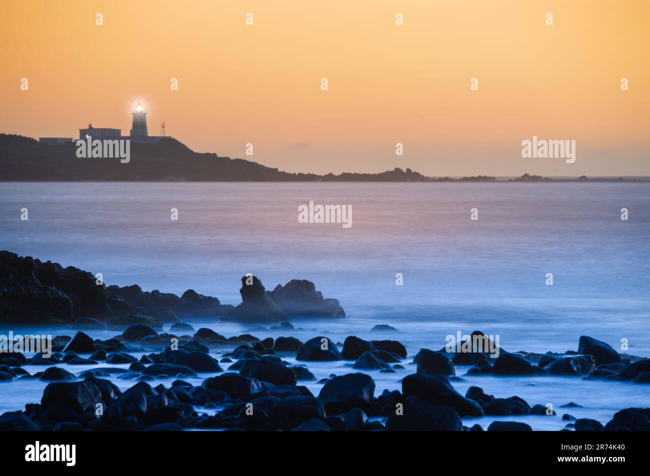 In der Dämmerung ist die Sonne hinter dem Leuchtturm. Das Fugui Cape Lighthouse in Shimen. Taiwan Stockfoto