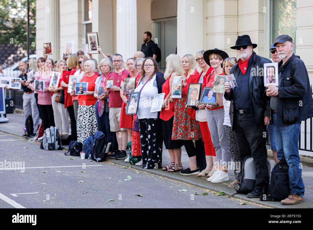 Menschen halten Bilder von Angehörigen, die während der Pandemie verloren gegangen sind, außerhalb der britischen Covid-19-Untersuchung im Dorland House in London, die mit Beweisen für ihre erste Untersuchung (Modul 1) beginnen wird, um zu untersuchen, ob die Pandemie ordnungsgemäß geplant war und „ob das Vereinigte Königreich angemessen auf diese Eventualität vorbereitet war“. Foto: Dienstag, 13. Juni 2023. Stockfoto