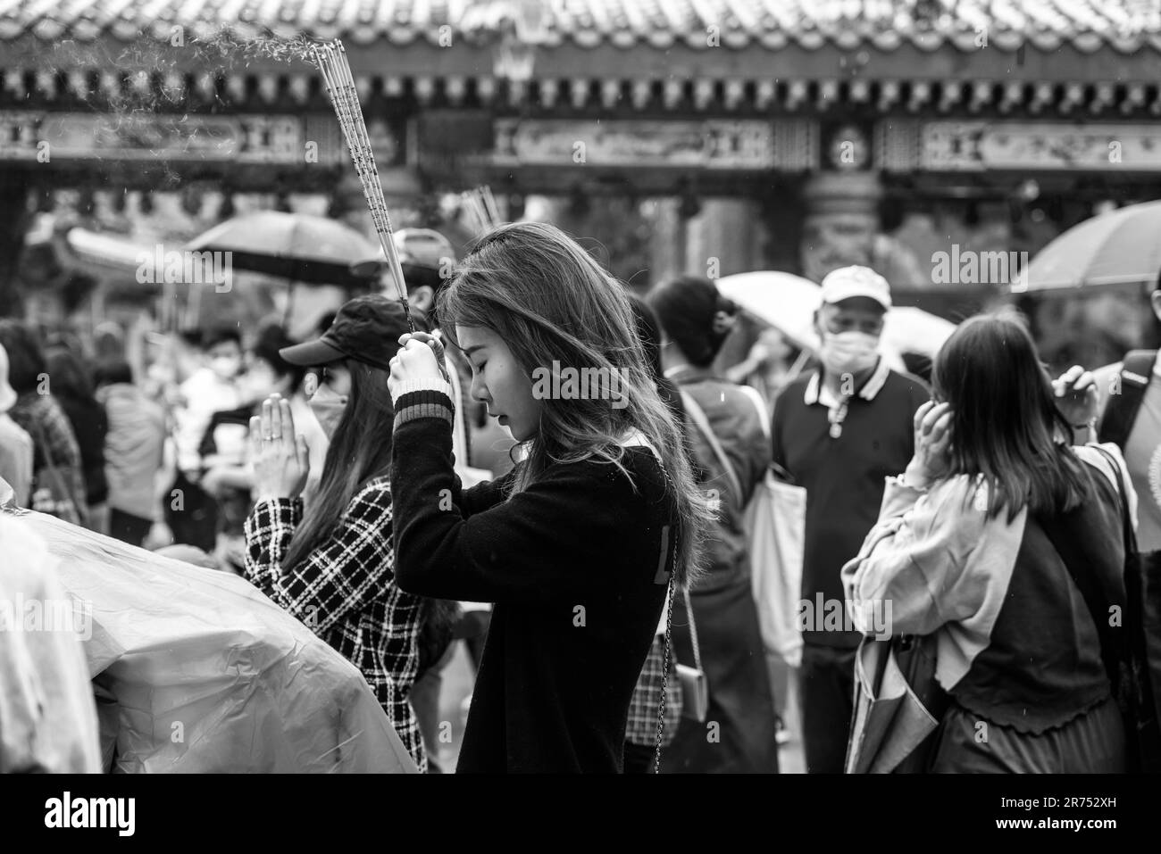 Junge Chinesen Beten Im Wong Tai Sin Tempel An, Hongkong, China. Stockfoto