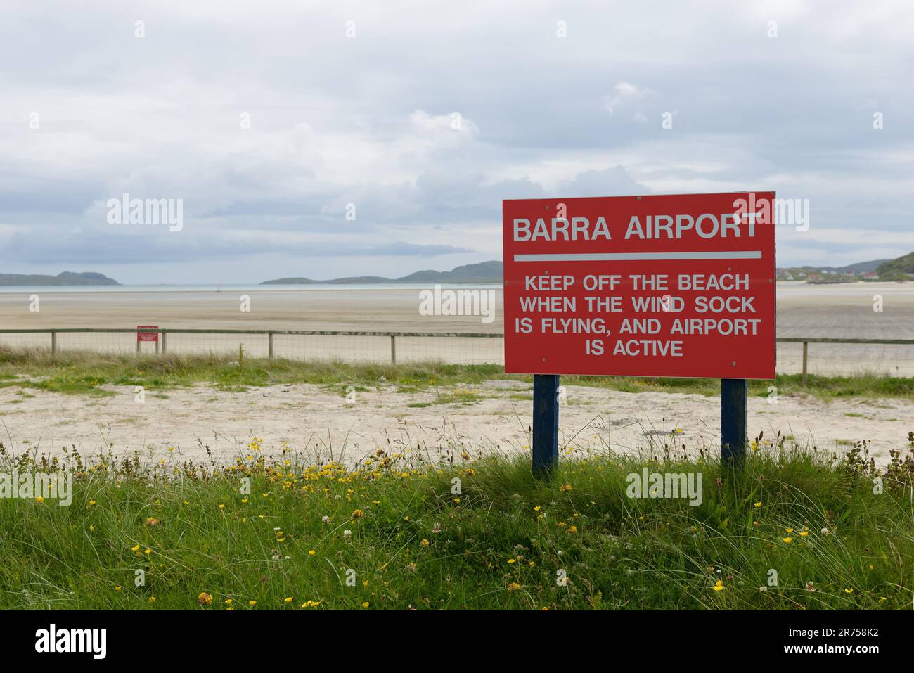 Warnschild „vom Strand fernhalten“ am Rand des Barra Beach Flughafens auf der hebridischen Insel in Schottland. Stockfoto