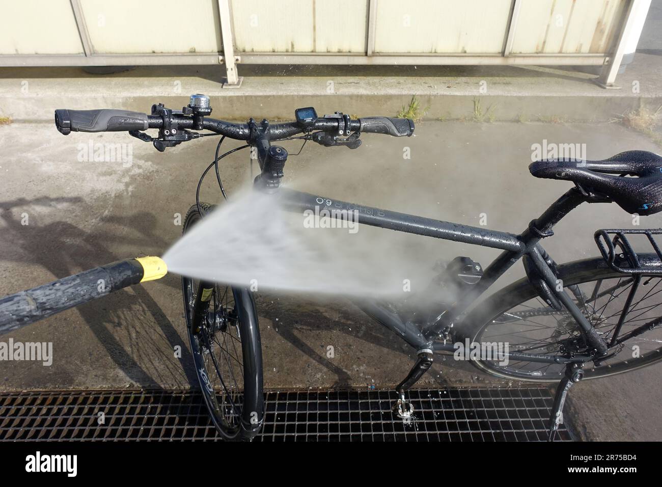 Das Fahrrad ist mit einem Wasserschlauch abgespritzt Stockfoto