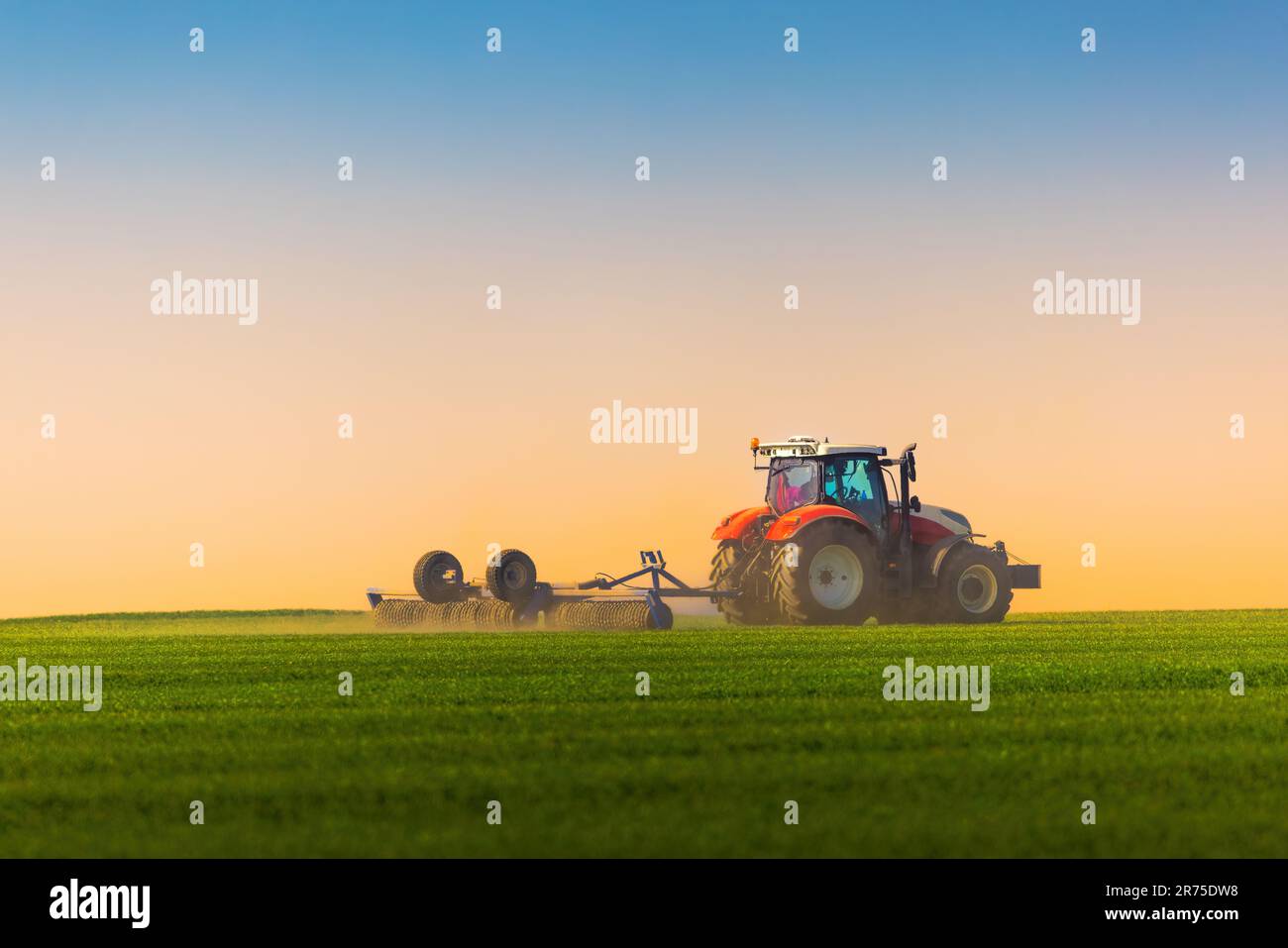 Landwirt in Vorbereitung der Flächen mit Saatbeet Grubber Traktor Stockfoto