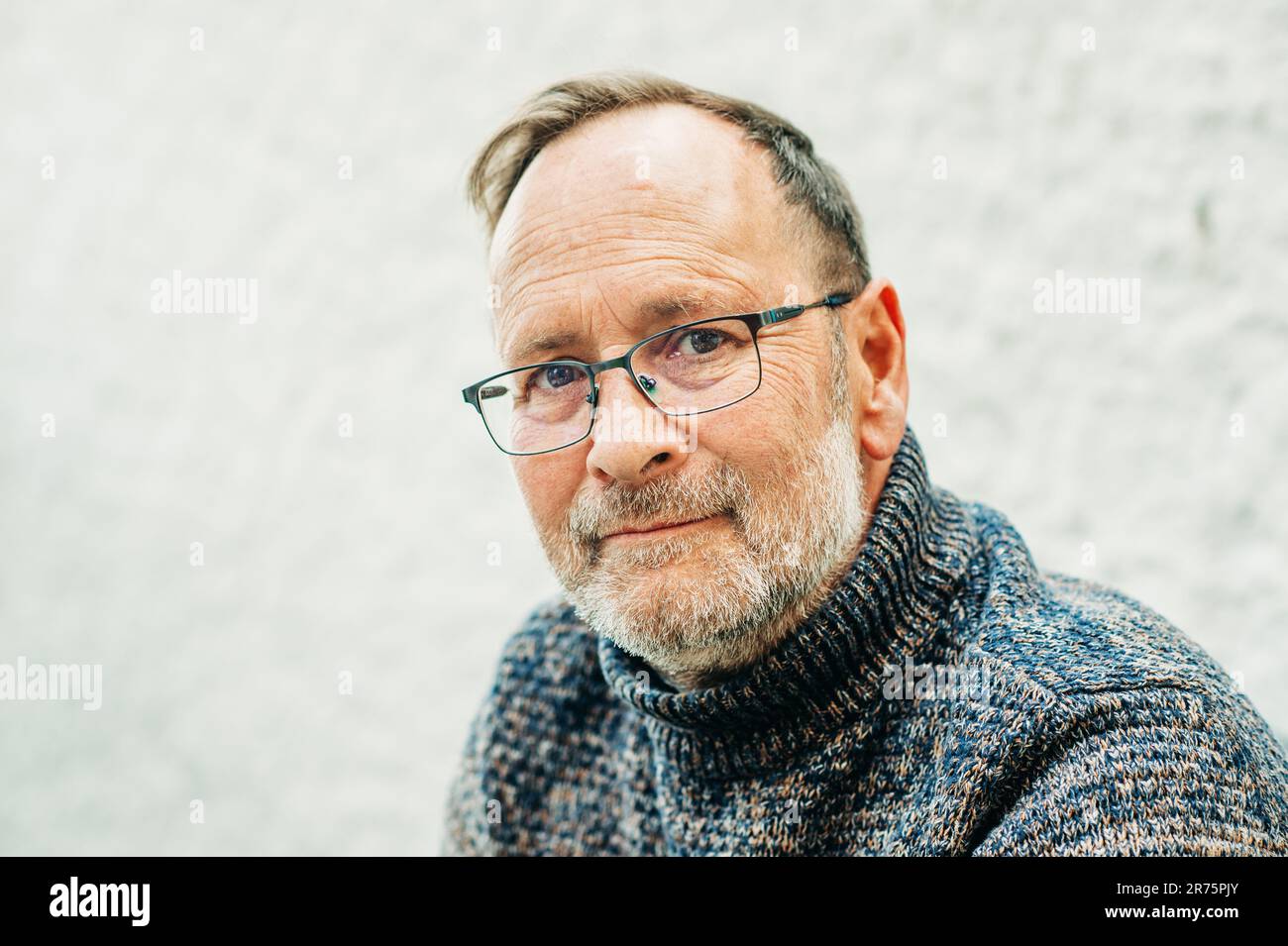 Außenporträt eines 50-jährigen Mannes mit braunem Pullover und Brille Stockfoto