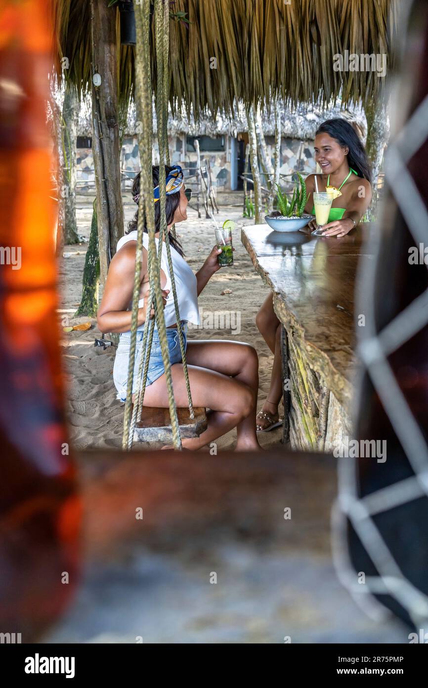 Nordamerika, Karibik, Großantillen, Hispaniola, Dominikanische Republik, North Coast, Puerto Plata Province, Cabarete, Natura Cabana, zwei hübsche Latinas genießen einen Drink an der Strandbar Stockfoto