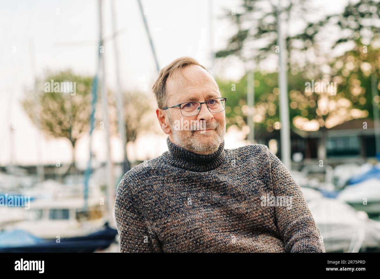 Außenporträt eines 50-jährigen Mannes mit braunem Pullover und Brille Stockfoto