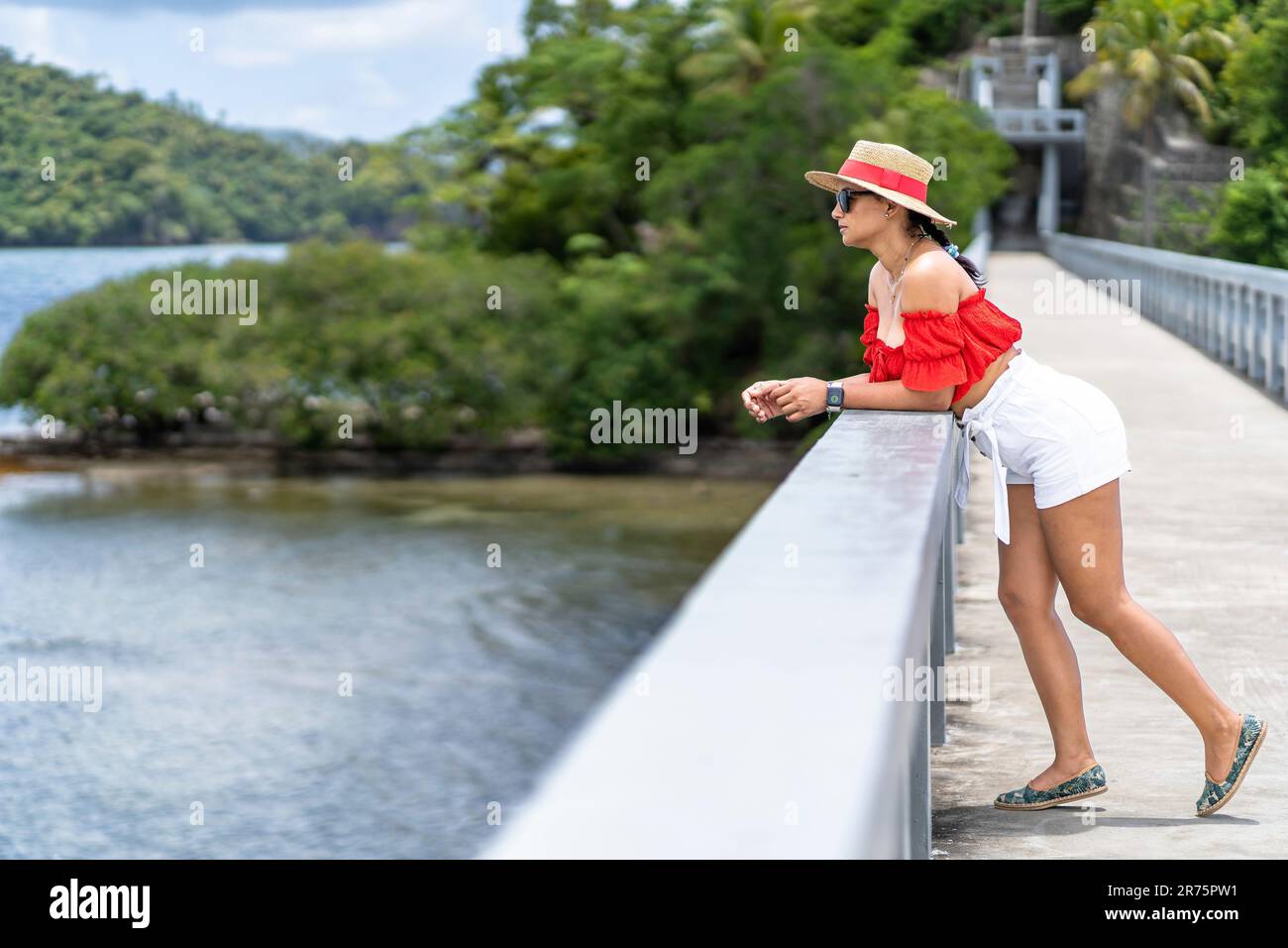 Nordamerika, Karibik, Großantillen, Hispaniola, Dominikanische Republik, Sama Province, Sama Halbinsel, Santa rbara de Sama, hübsche Latina, die sich am Geländer der berühmten Brücke lehnt und die Sama Bay betrachtet Stockfoto