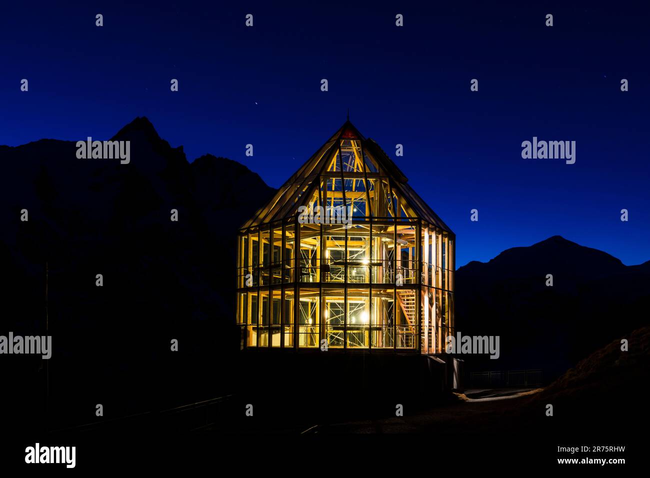 Wilhelm Swarovski Observatory, bei Nacht mit eingeschalteten Lichtern und Silhouette im Berghintergrund Stockfoto