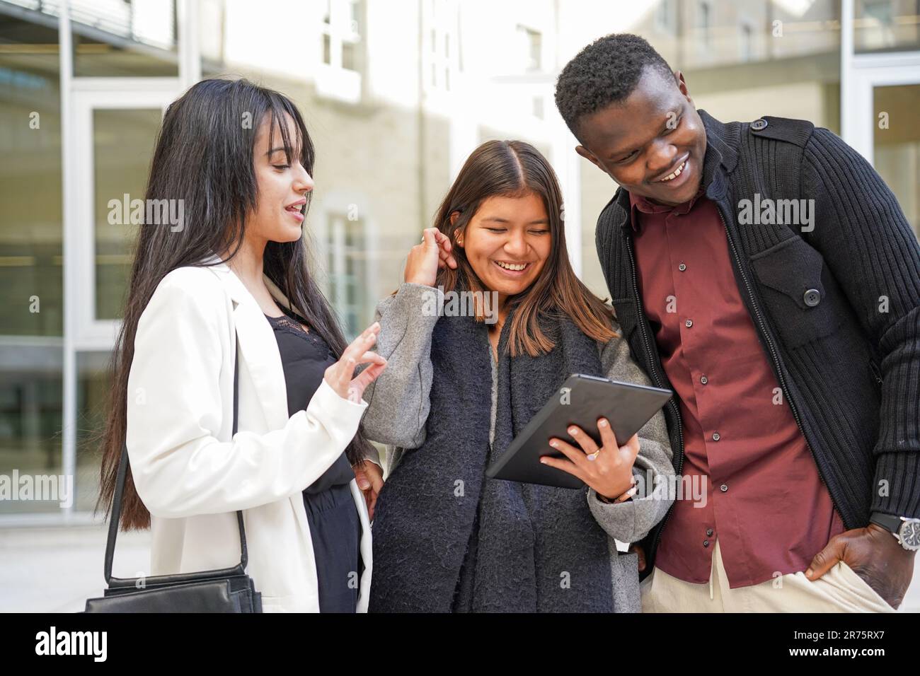 Gute Zusammenarbeit lateinamerikanischer und afrikanischer Geschäftsleute mit Technologie. Junge multiethnische und erfolgreiche Unternehmer mit einem Tablet Stockfoto