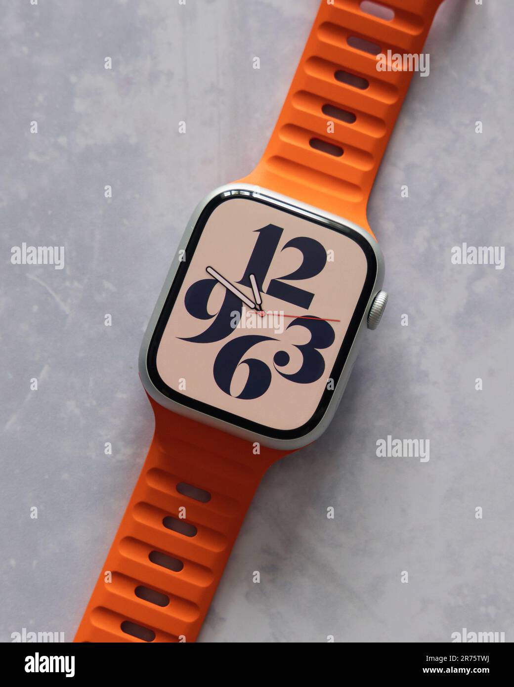 LONDON - 7. JUNI 2023: Apple Watch mit leuchtend orangefarbenem Band und Display für die Uhr Stockfoto