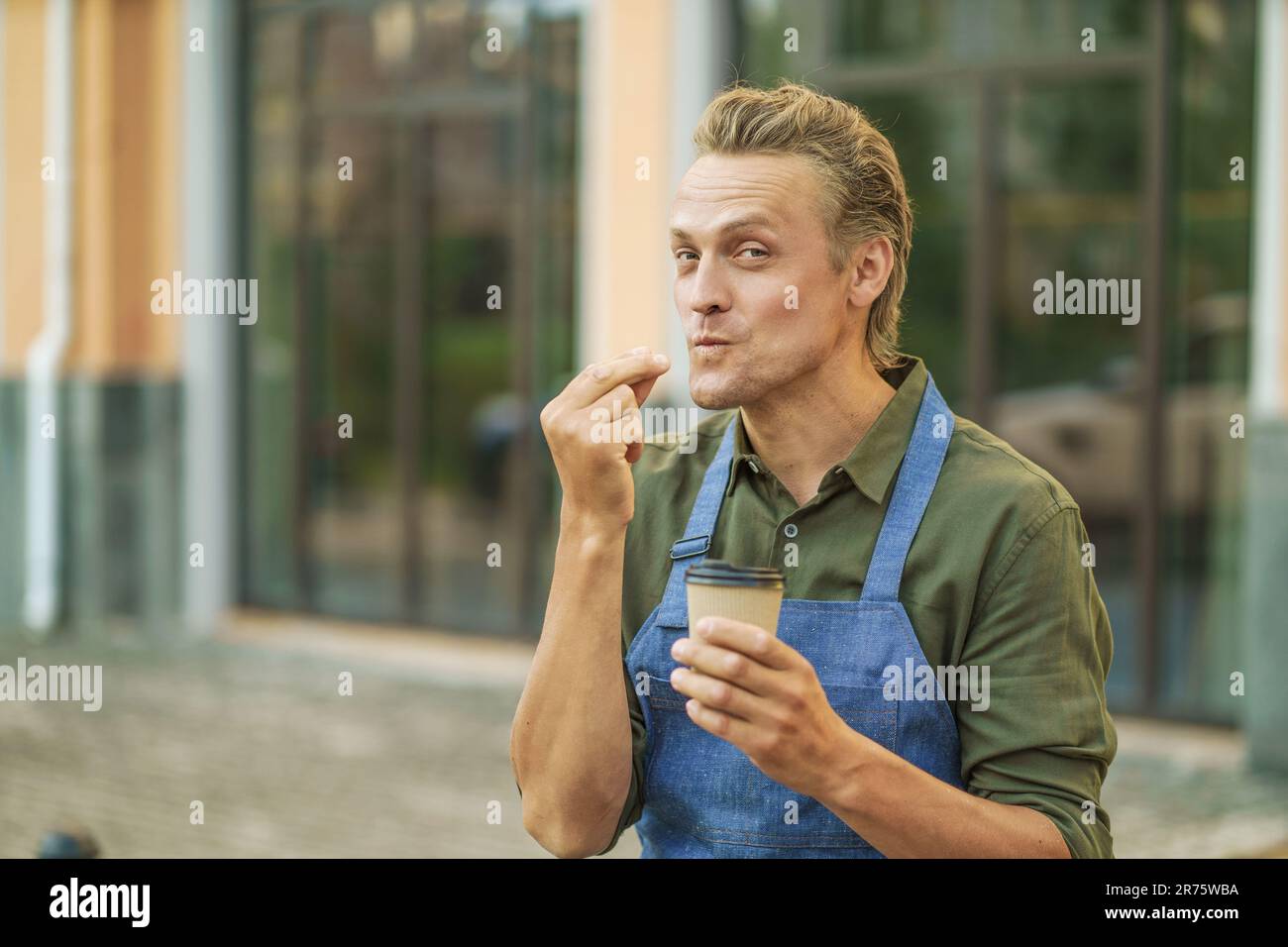 Der Barista trägt eine Schürze und demonstriert den köstlichen ...