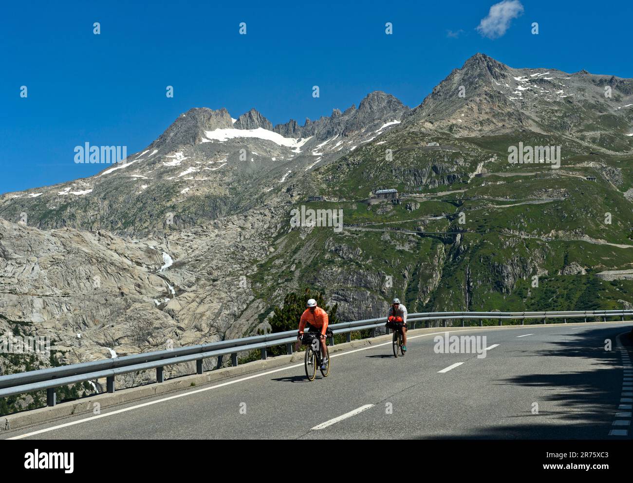 Radfahrer auf dem Abstieg vom Furka Pass, im hinteren Teil des eisfreien Bettes des Rhone-Gletschers, Furkapas Road bei Gletsch, Wallis, Schweiz Stockfoto