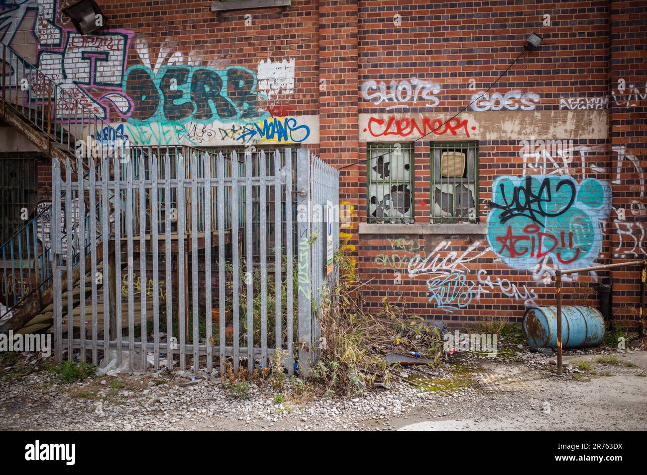 Eine Wand, die mit Graffiti bedeckt und vandalisiert wurde. Konzept von Verfall, Vernachlässigung oder Verlassen. Stockfoto