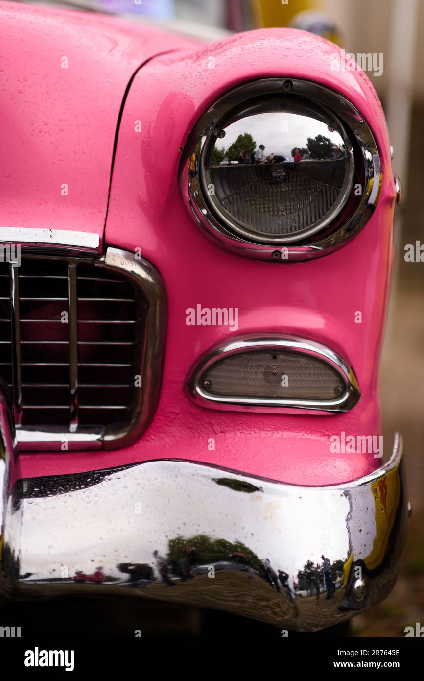 Izmir, Türkei - 3. Juni 2023: Fokussierte Nahaufnahme eines einzelnen Scheinwerfers auf einem rosa 1955 Chevrolet Belair bei einem Oldtimer-Event Stockfoto