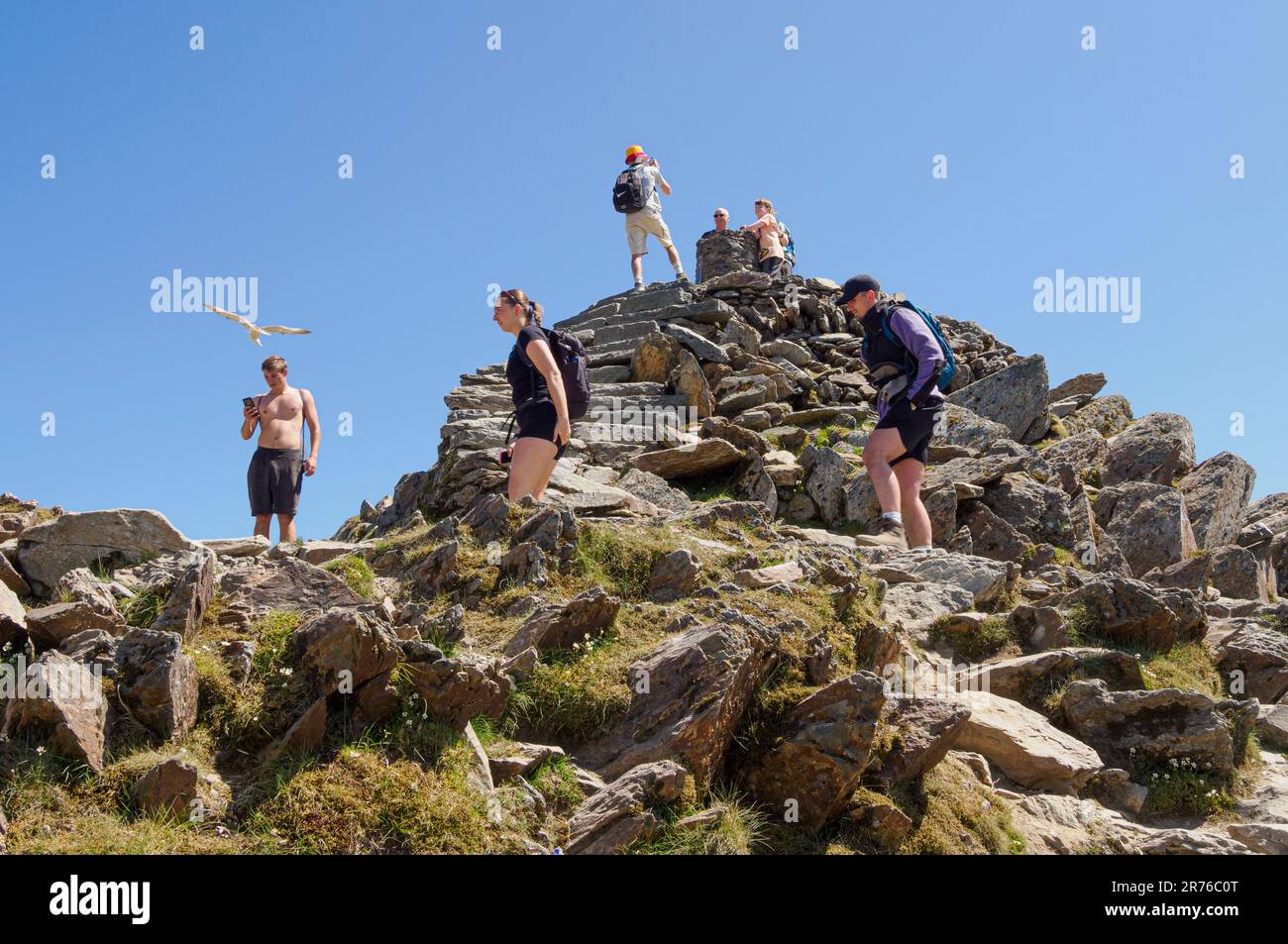 Spaziergänger machen Fotos und genießen eine Pause an einem heißen Sommertag auf dem Gipfel des Snowdon Yr Wyddfa im Eryri National Park North Wales UK Stockfoto