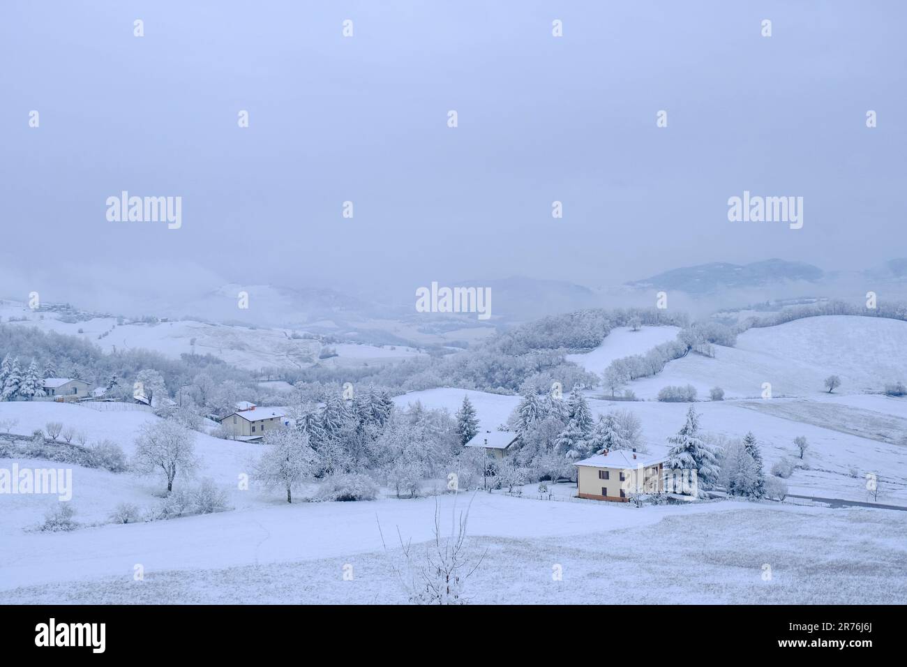 Winterlandschaft. Schneebedeckte Hügel, Häuser, Natur, Horizont. Natürlicher Hintergrund. Appennino Tosco-emiliano-Nationalpark Stockfoto