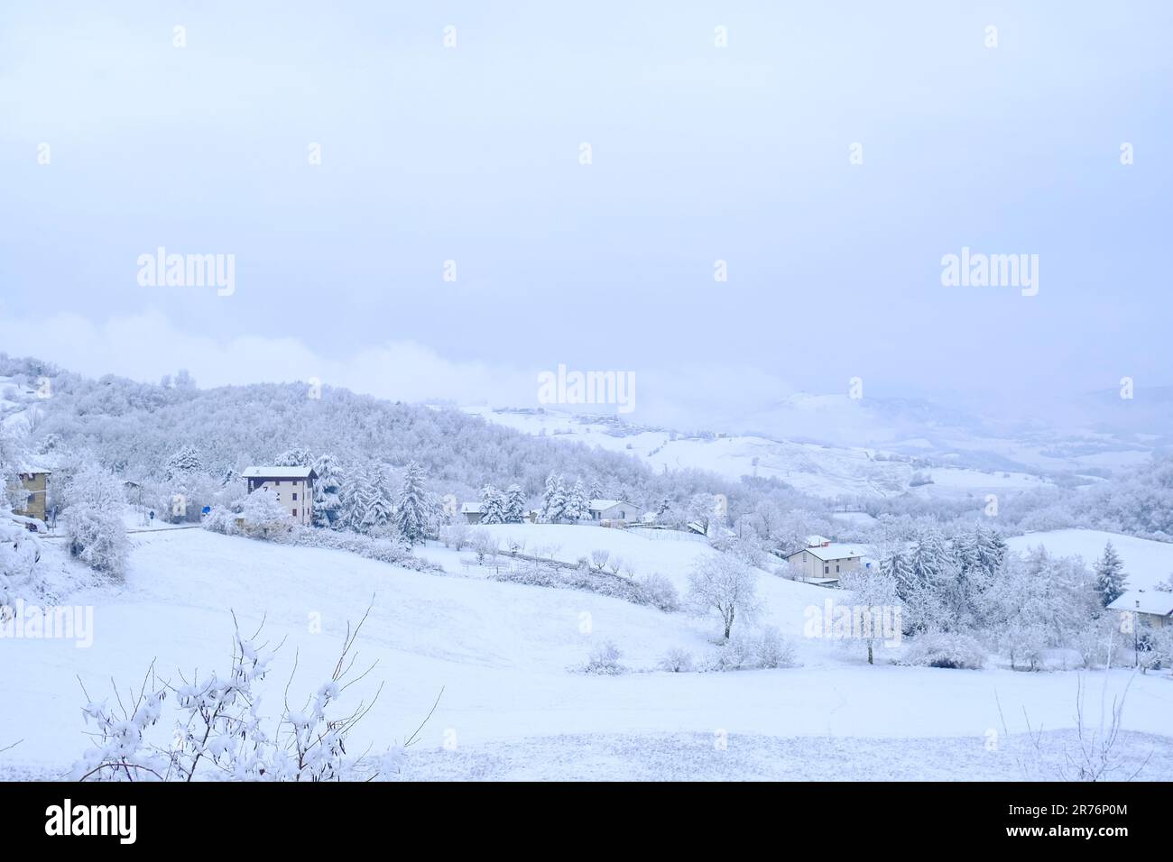 Schneesturm in den Bergen. Schneebedeckte Hügel, Berge, Dorf, Natur, Horizont. Natürlicher Hintergrund. Appennino-Tosco-emiliano Stockfoto