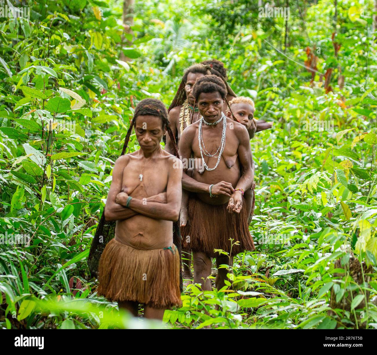Die Bewohner des Dorfes des KorowaiStammes kehren aus dem Wald zurück