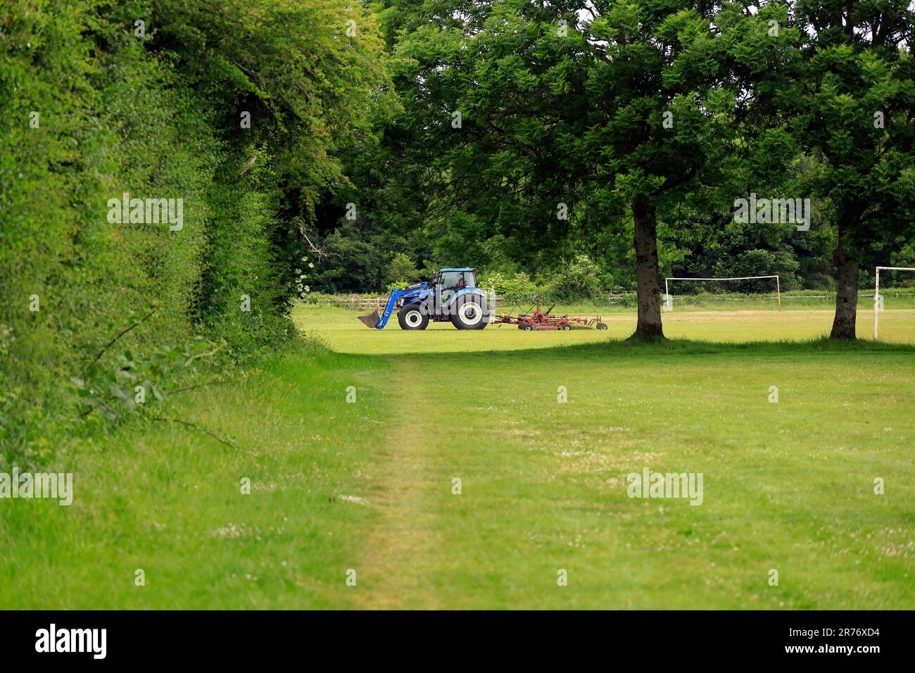 Blauer Traktor mäht Gras auf Pontcanna Fields, Cardiff. Juni 2023. Sommer Stockfoto