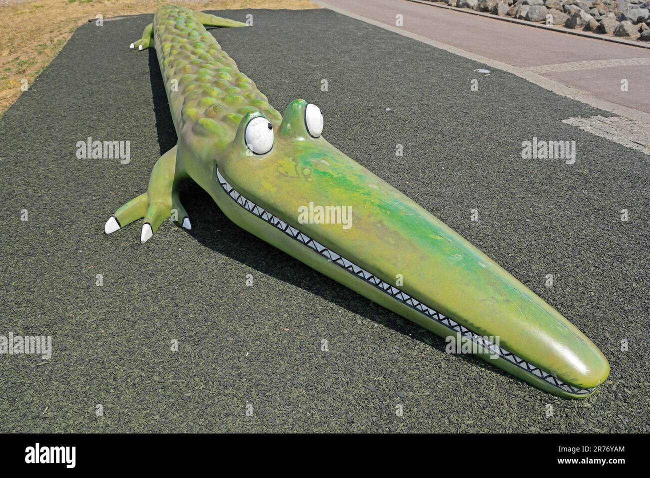 Crocky-Wock, das Krokodil - eine Figur von Roald Dahl aus dem Gedicht. Skulptur / Modell / lustige Kunstwerkbank am Cardiff Bay Barrage. Juni 2023. Sommer. Zyl. Stockfoto