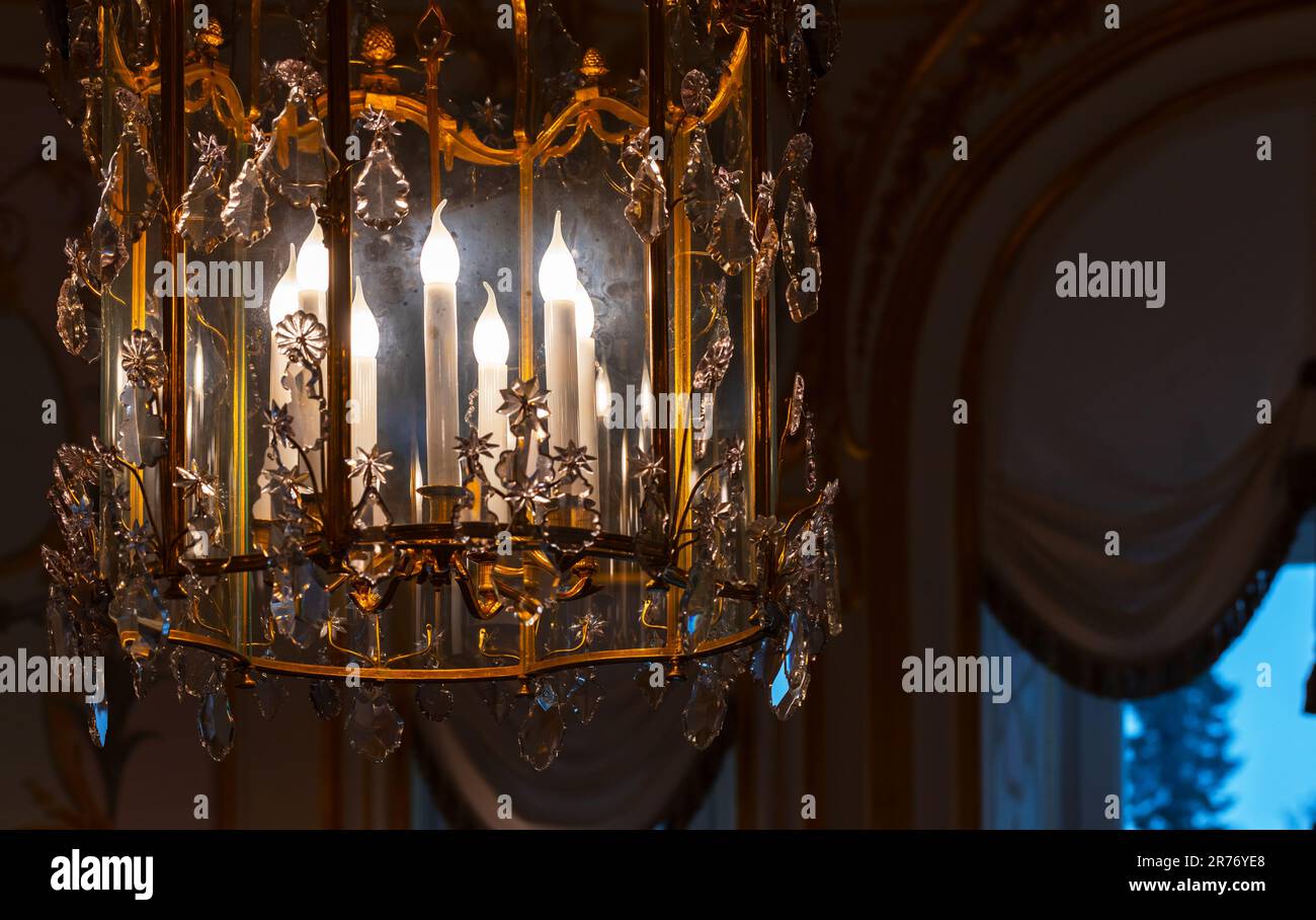 Ein Bruchteil eines luxuriösen Kronleuchters im klassischen Stil mit Kerzenlicht im Inneren. Nahaufnahme mit weichem, selektivem Fokus Stockfoto