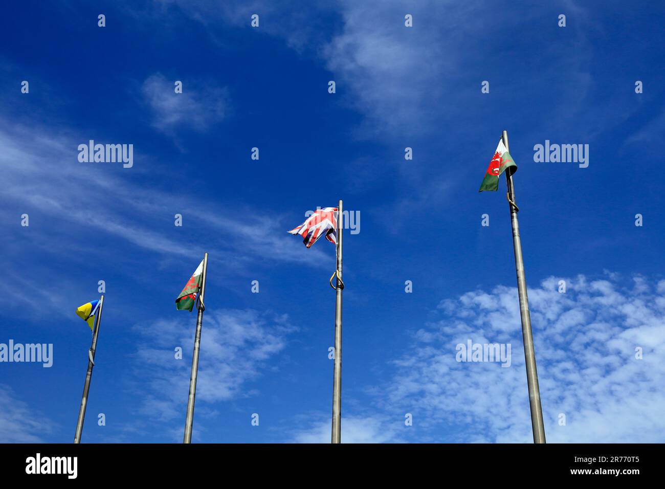 Flaggen auf einem Fahnenmast, Cardiff Bay. Ukraine, Vereinigtes Königreich und Wales vor einem blauen Himmel im Juni 2023. Sommer. Zyl. Stockfoto