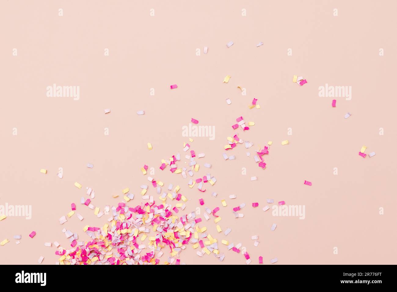 Leuchtend pinkfarbene, gelbe und farbenfrohe Streusel auf pinkfarbenem Hintergrund sorgen für eine feierliche Ankündigung. Stockfoto