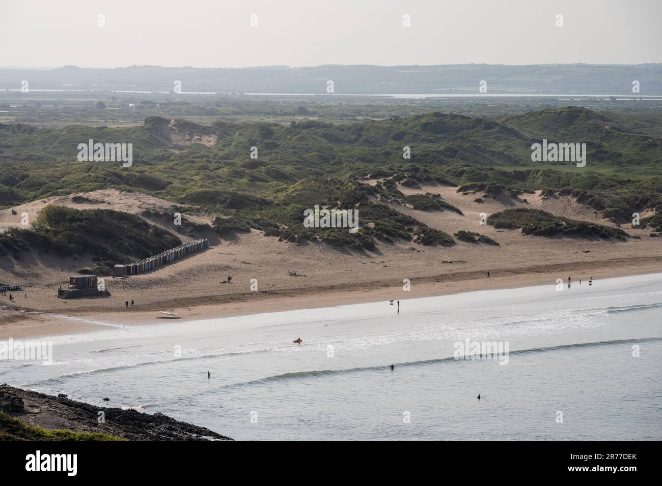 Surfer und Wanderer genießen den Strand am Braunton Sands in North Devon, hinter dem sich das Braunton Burrows Dünensystem und die Flussmündung des Flusses Taw befinden. Stockfoto