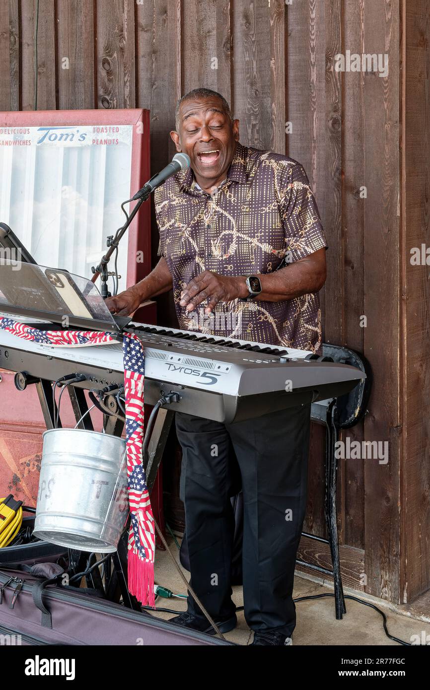 Ein schwarzer oder afroamerikanischer Musiker spielt und singt auf den Tastaturen bei einer Veranstaltung im Freien in Pike Road, Alabama, USA. Stockfoto