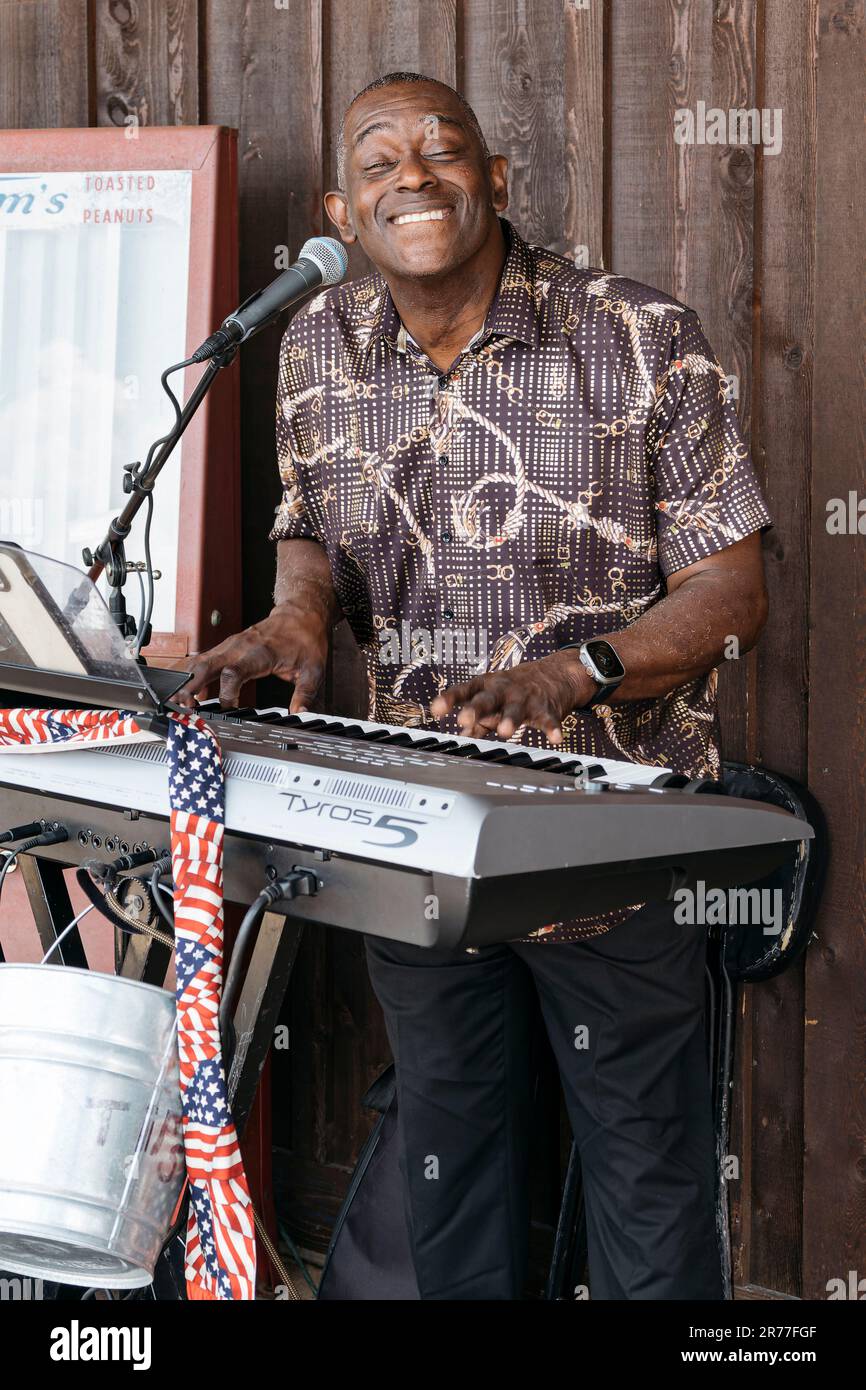 Ein schwarzer oder afroamerikanischer Musiker spielt und singt auf den Tastaturen bei einer Veranstaltung im Freien in Pike Road, Alabama, USA. Stockfoto