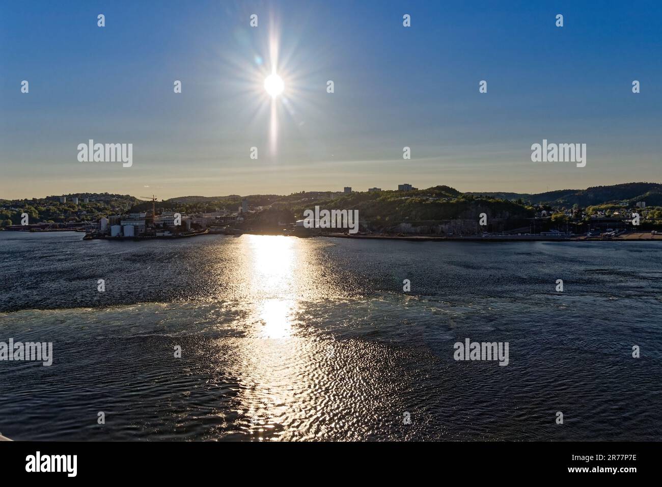 Norwegische Landschaft mit der Sonne am Himmel, die im Meer reflektiert Stockfoto