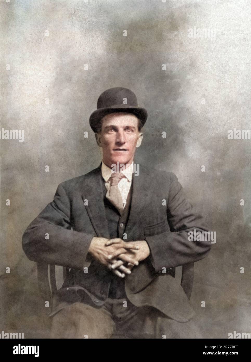 Vintage-Porträt eines Mannes, der einen dreiteiligen Anzug und eine Bowler-Mütze trägt, Cirica 1910, farbig. Stockfoto