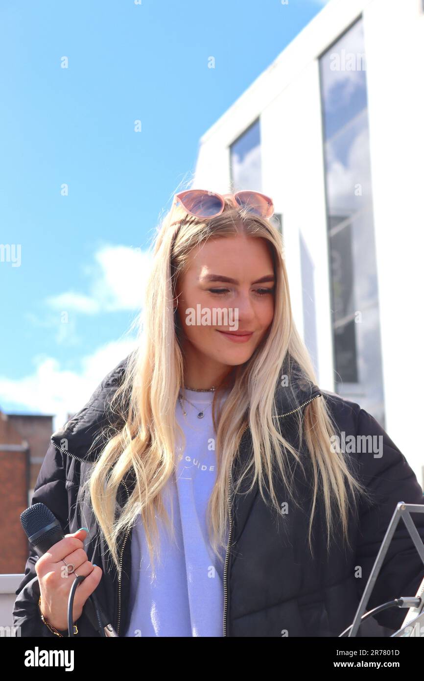 Die Sopransolistin und Straßenkünstlerin Nancy Longland bereitet ihren nächsten Musiktitel während ihrer Aufführung im Precinct, Southampton, Hampshire, vor. Stockfoto