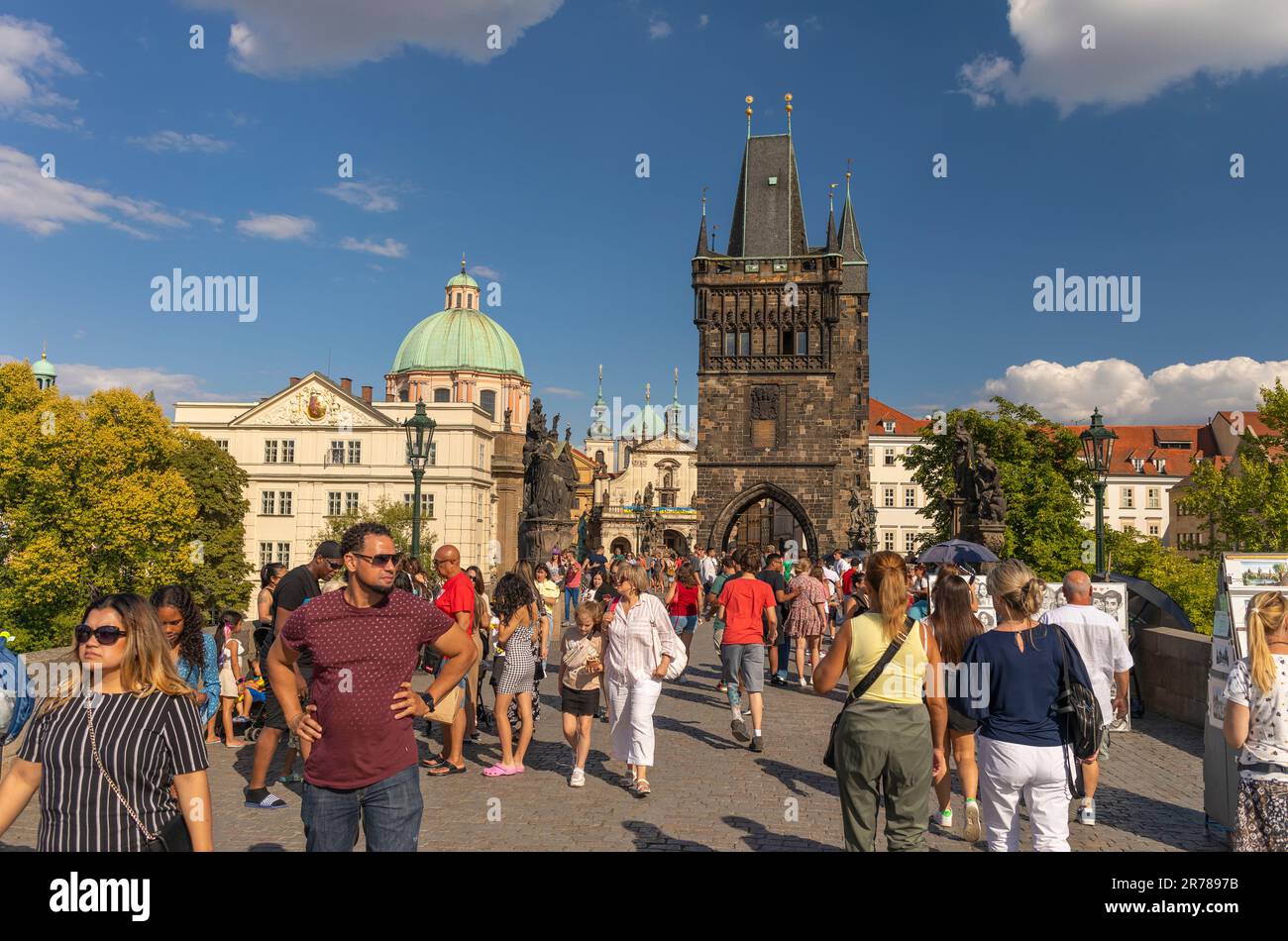 PRAG, TSCHECHISCHE REPUBLIK - Touristen, die die Karlsbrücke überqueren. Der Old Town Bridge Tower befindet sich hinter dem Gebäude. Stockfoto