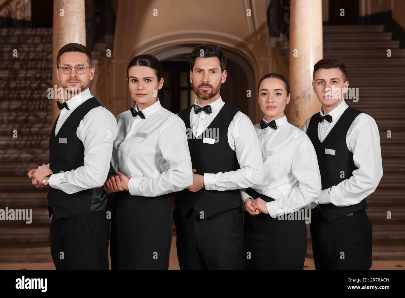 Gruppe von Trainees, die formelle Kleidung im Hotel tragen. Professionelle Butler-Kurse Stockfotografie