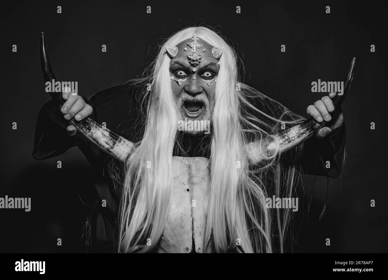 Dracula - Halloween-Konzept. Böser Vampirmann. Magie und Märchenkonzept. Vampirmann mit weißen Augen. Brennender Dämon ruft böse Mächte herbei Stockfoto