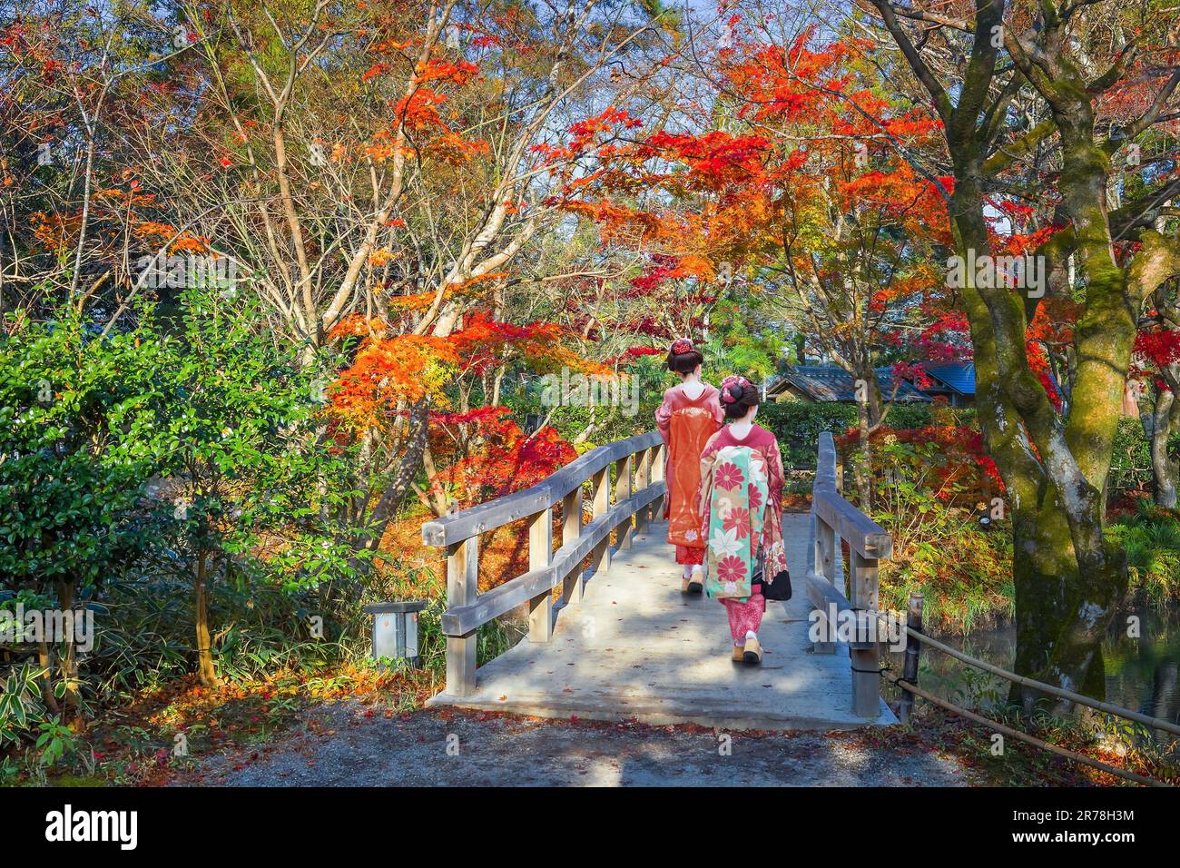 Japanische Geisha mit traditionellem Kimono-Kostüm in Herbstlandschaft in einem Park im berühmten Yufuin Resort Town Stockfoto